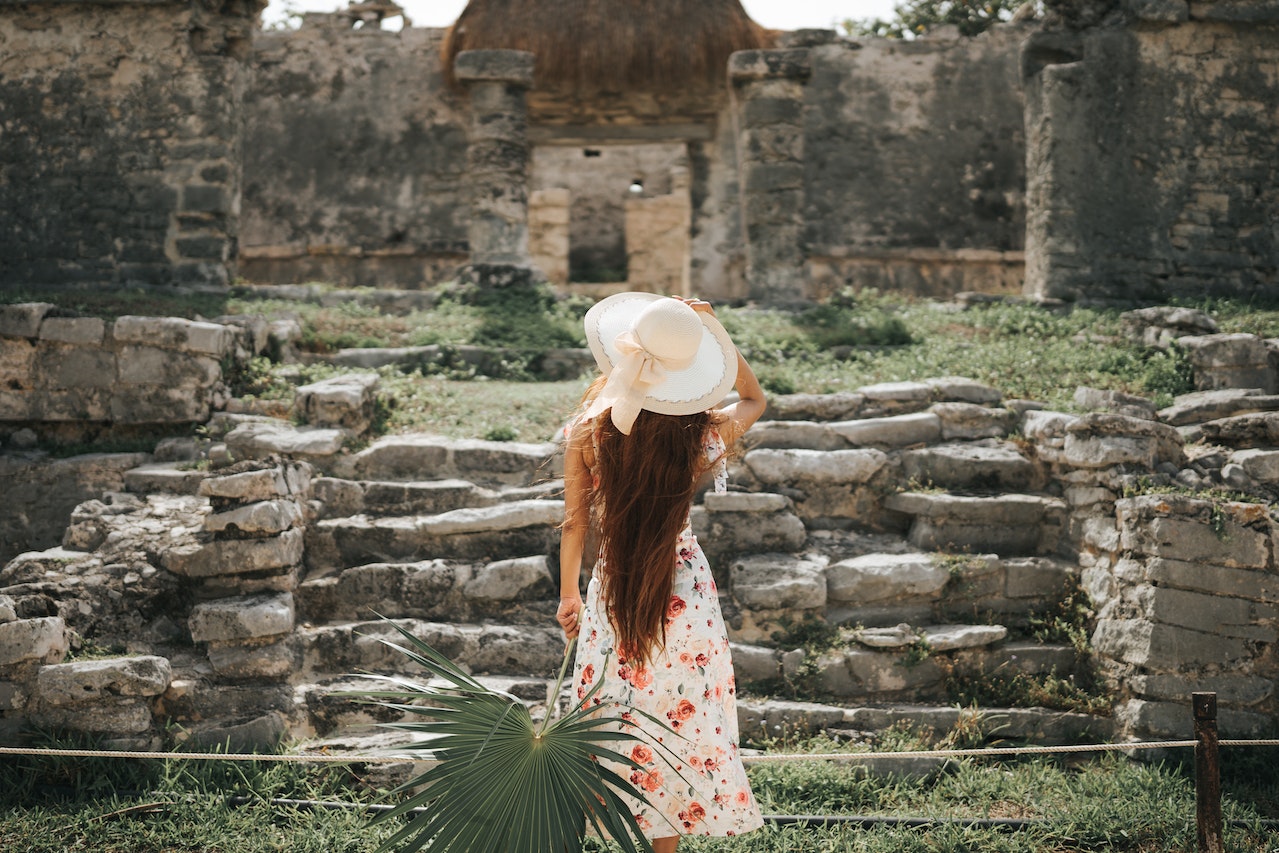 A woman standing in front of Mayan ruins.