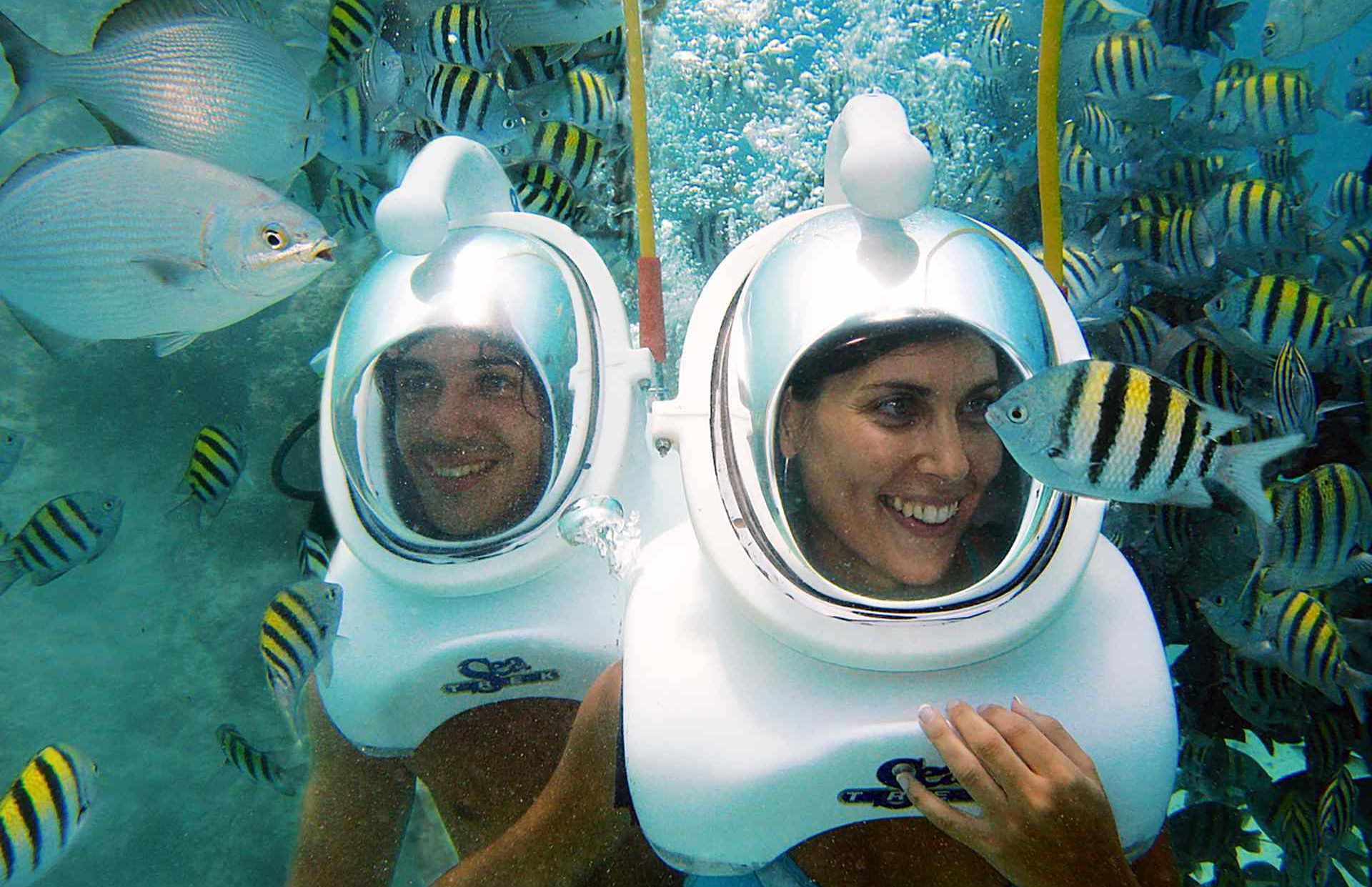 man and woman with underwater diving helmets