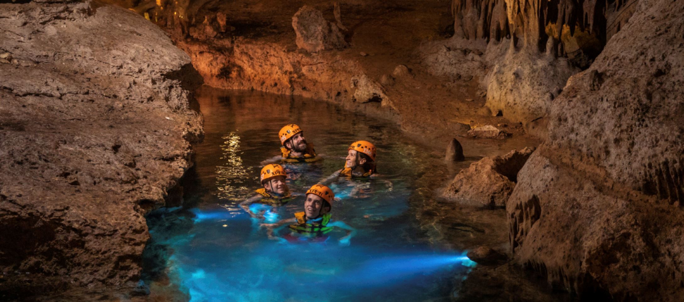 family swimming in cenote cave