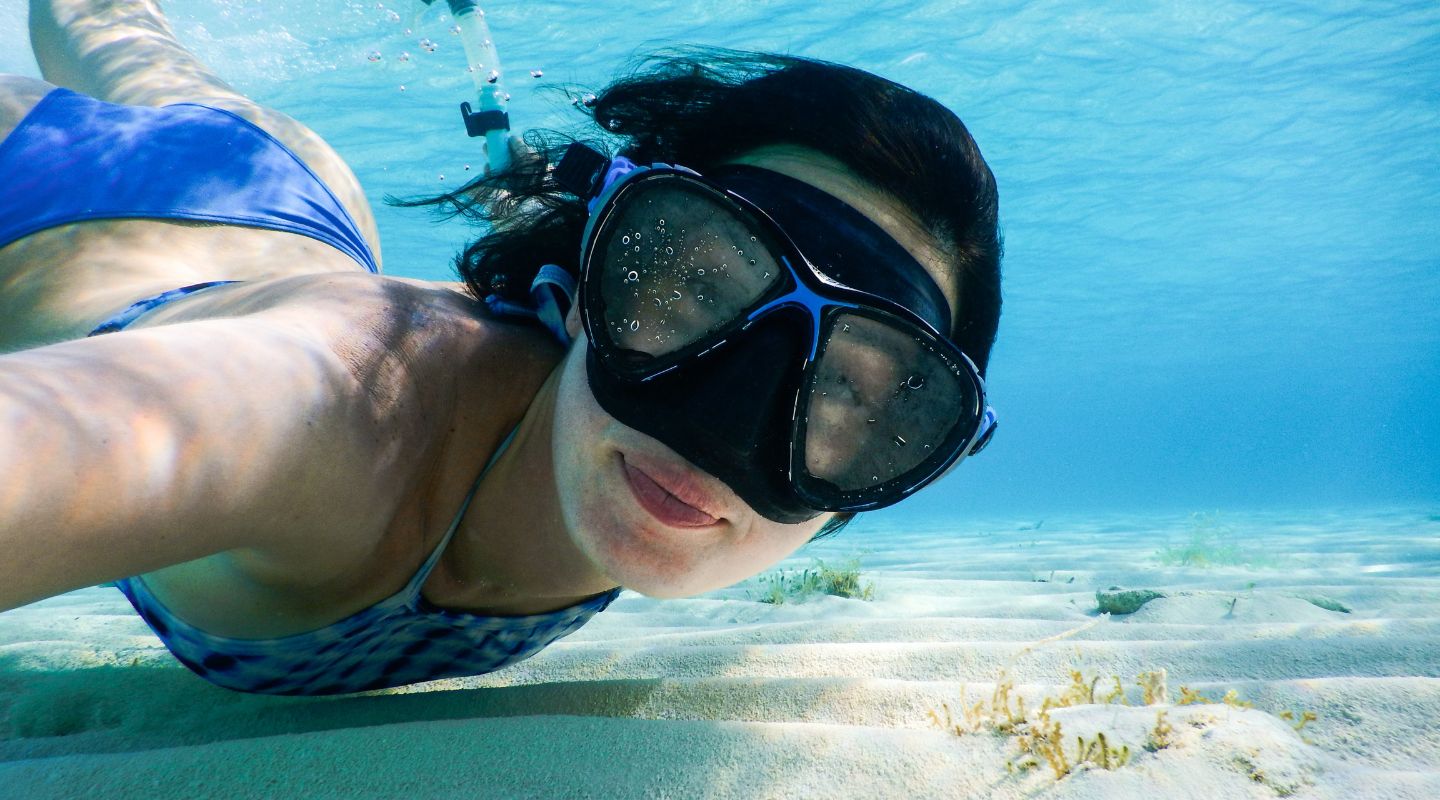 Woman snorkeling and smiling at the camera