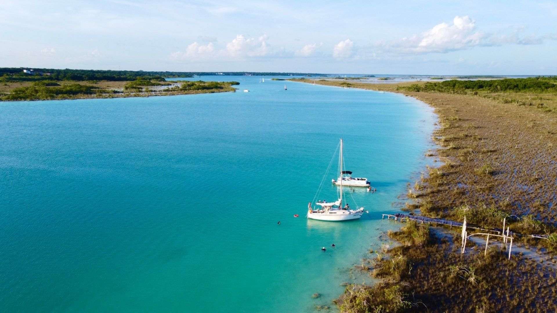 overview of Bacalar Lagoon with two sailboats at shore
