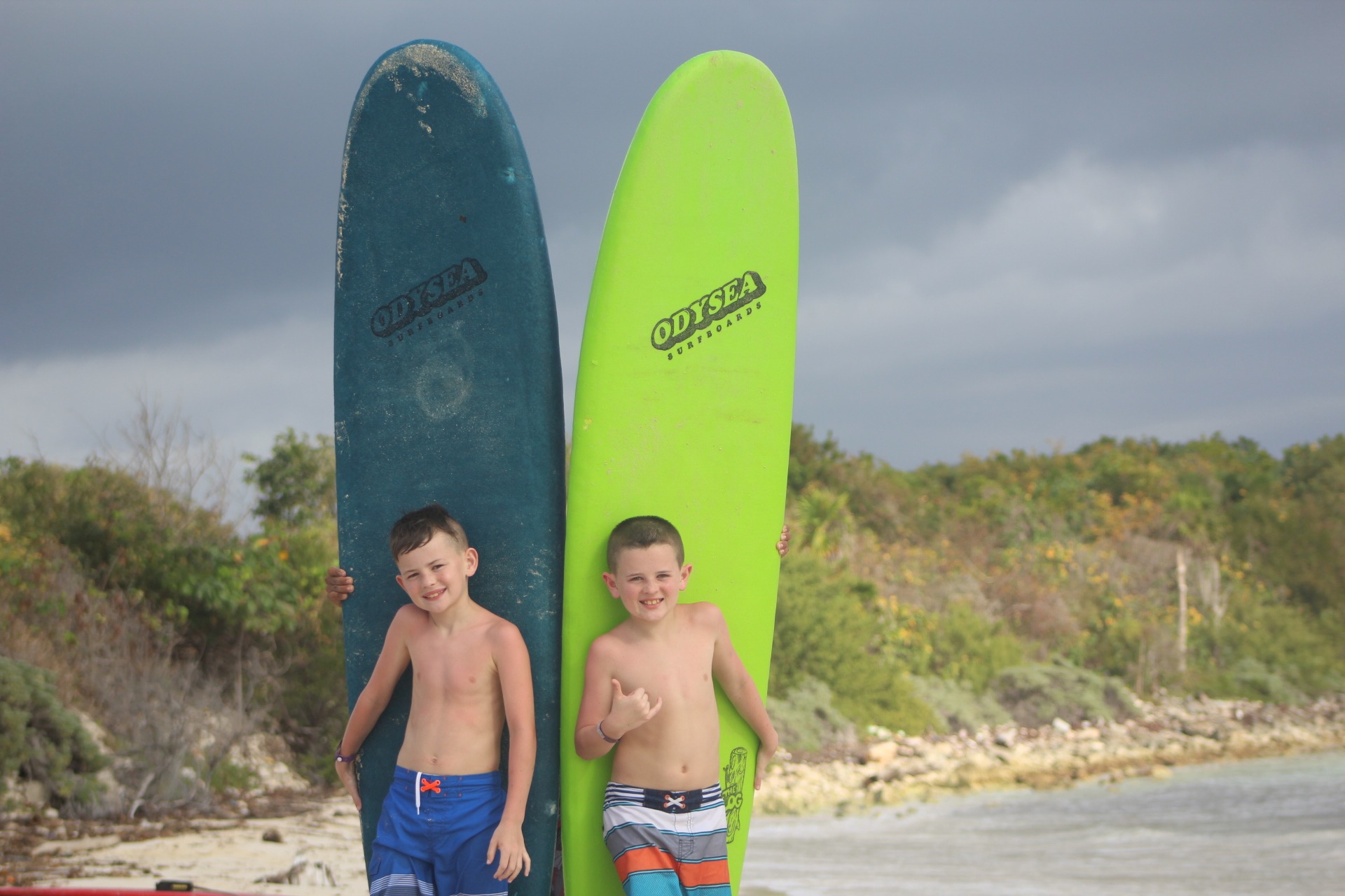 2 boys with surfboards on beach