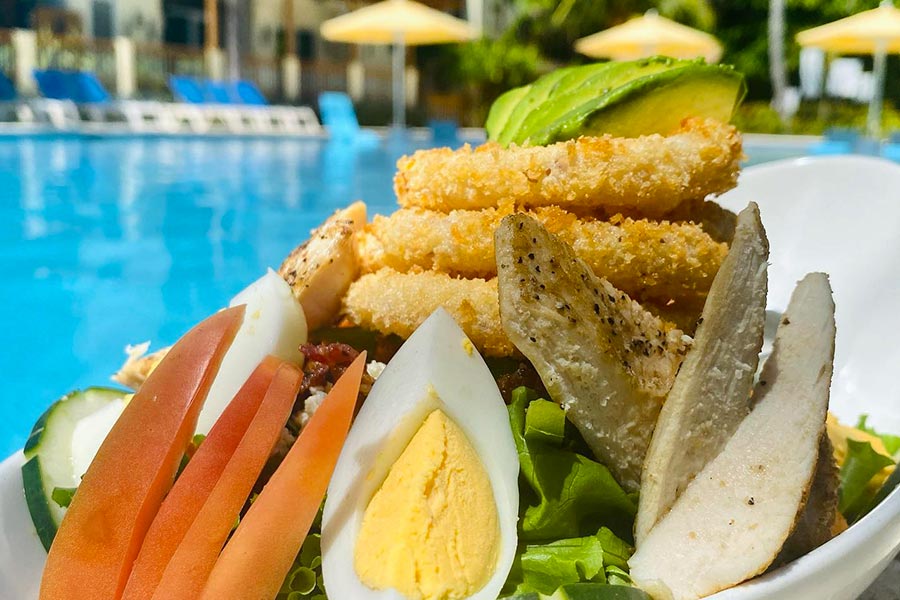 Poolside meal at Iron Shore Grill - photo by Iron Shore Grill (https://www.facebook.com/GrandRoatanCaribbeanResort/photos/1921814034644001)