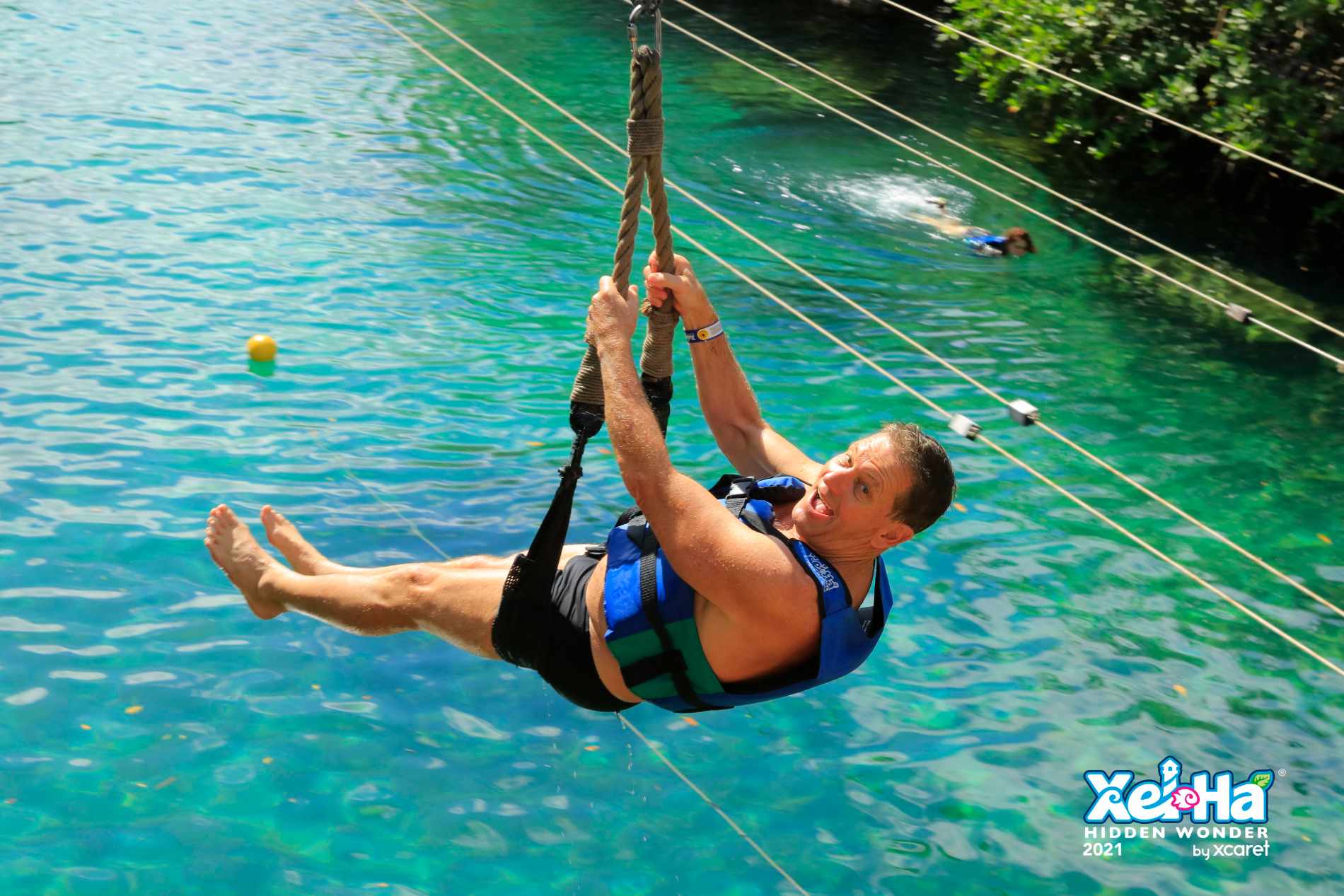 man riding zipline into the water