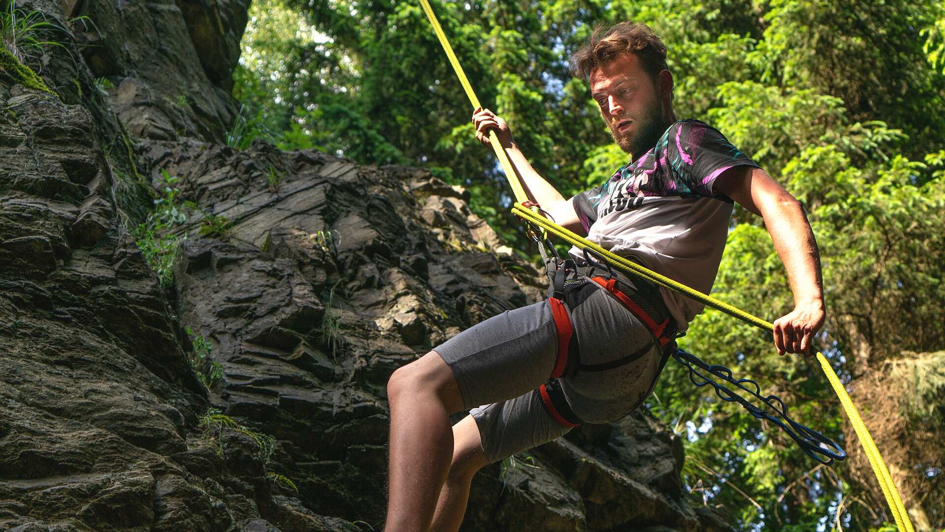 man rappelling down cliff