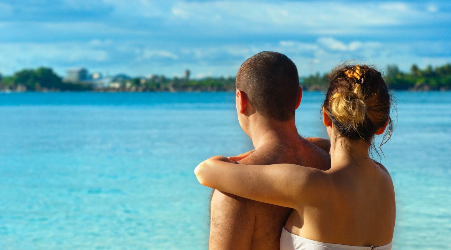 Woman and man embracing on the beach.