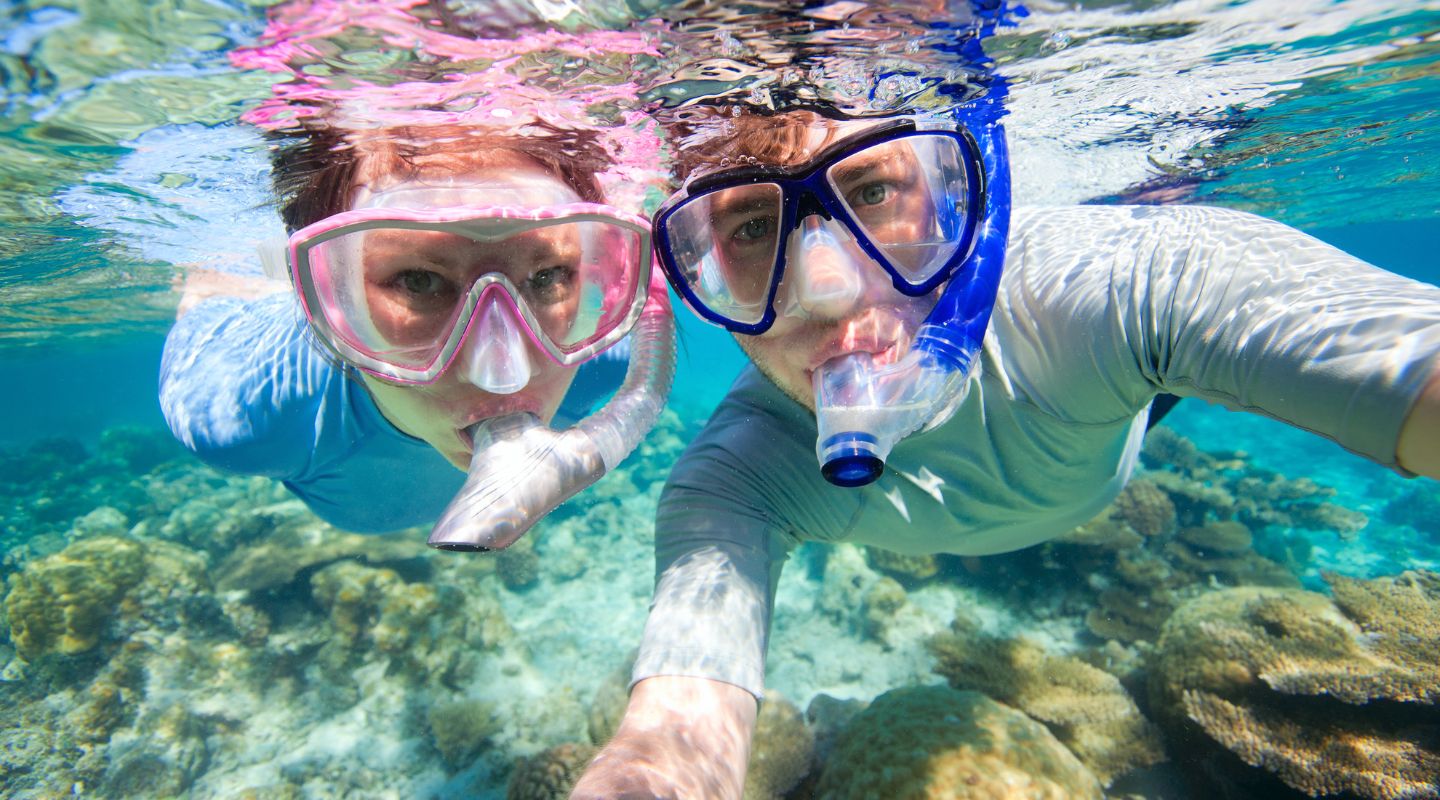 Couple snorkeling and looking at the camera