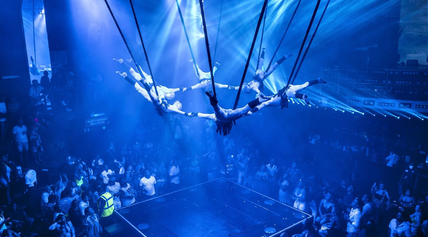 A group of dancers are suspended mid-air during a live performance at Coco Bongo