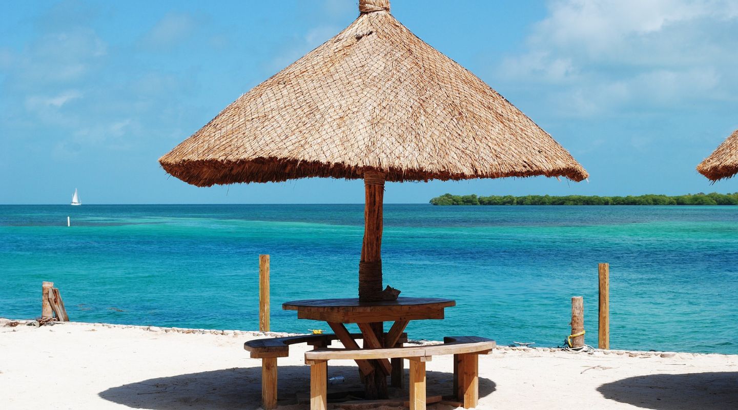 Small palm tree roof hut next to the ocean