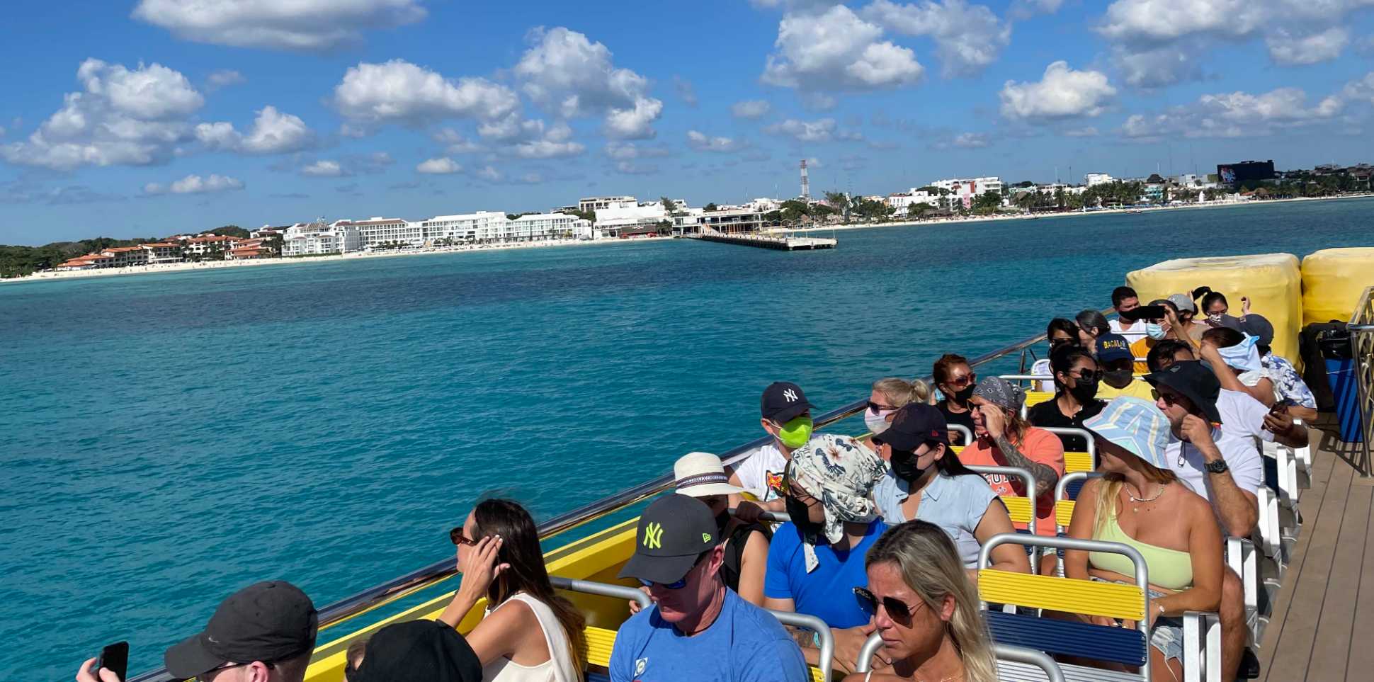 people on rooftop of ferry with Playa Del Carmen in background