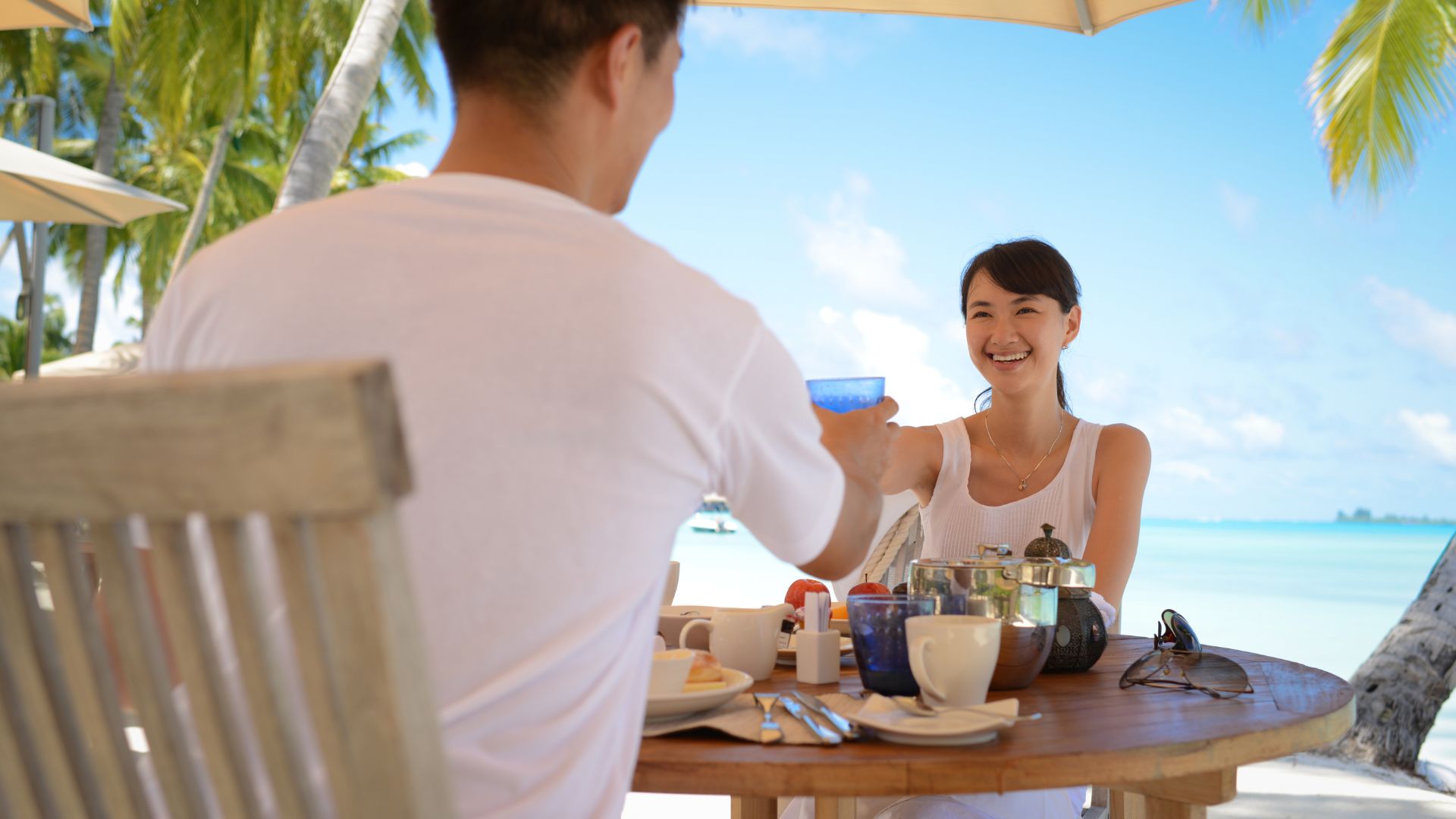 A couple sitting at a restaurant table and having fun