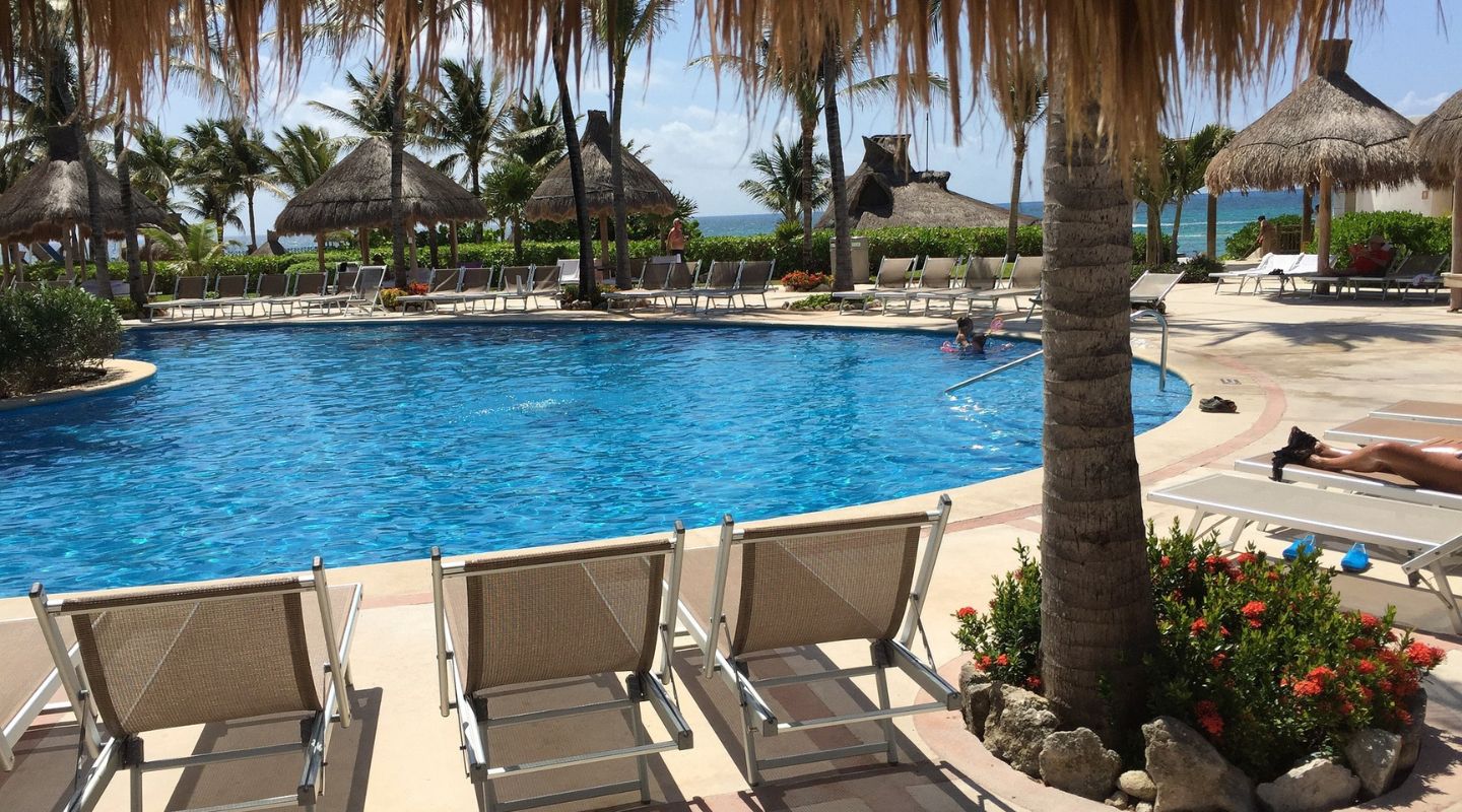 A group of plastic loungers surround a pool