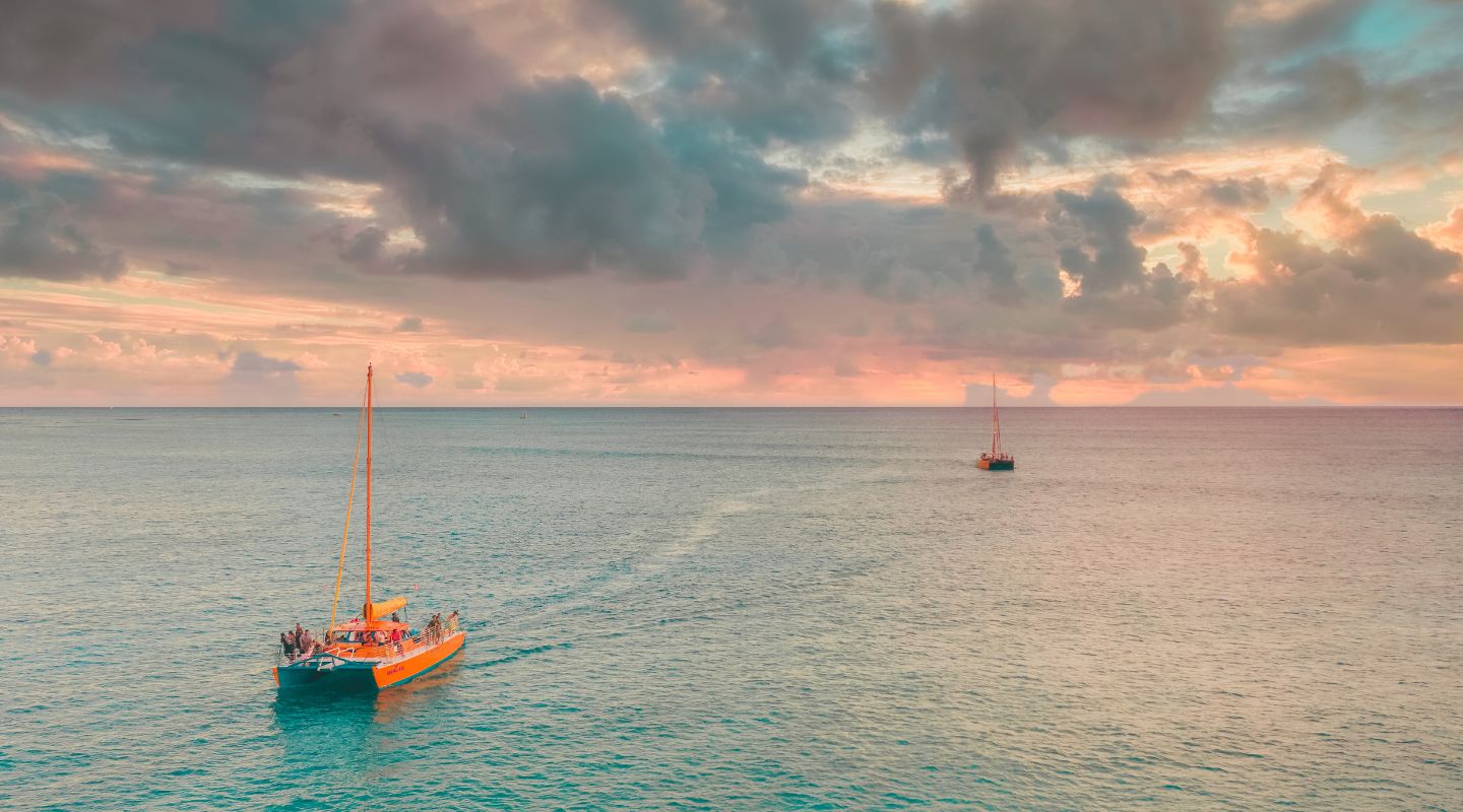 Catamaran sailing at sunset