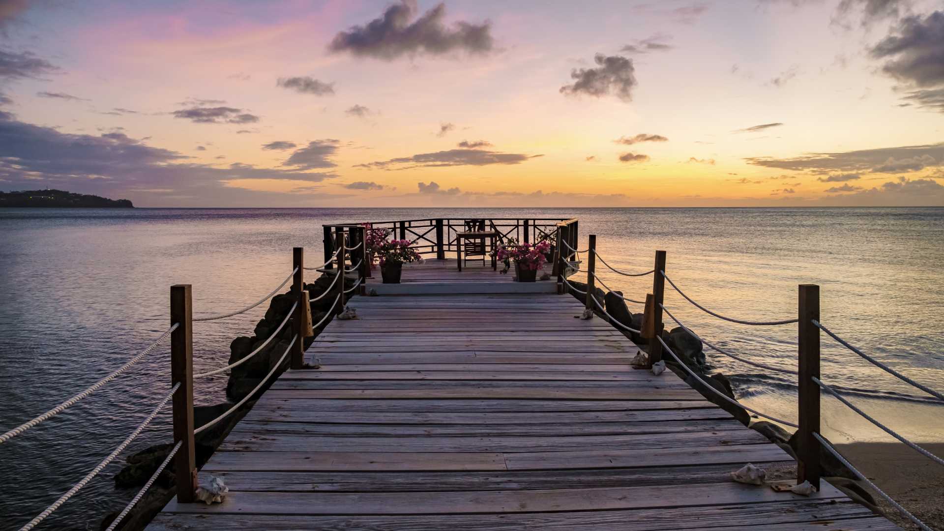 dock over the ocean with sunset behind