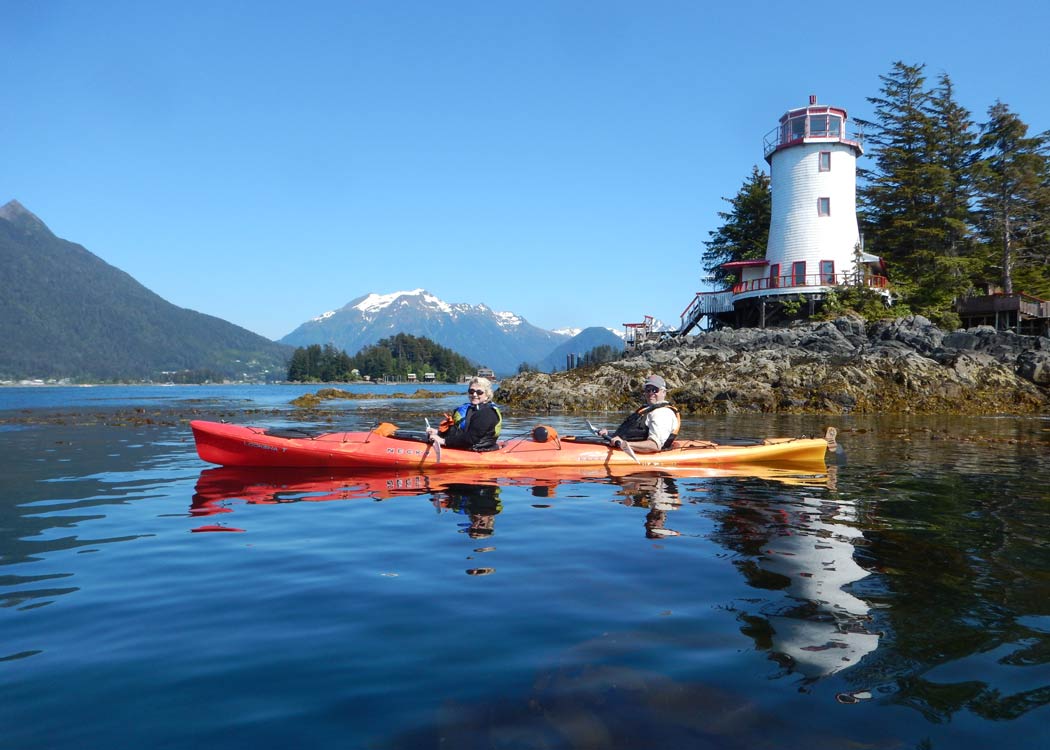 Kayakers enjoying scenic lighthouse views on the Sitka Sound Paddle & Cruise