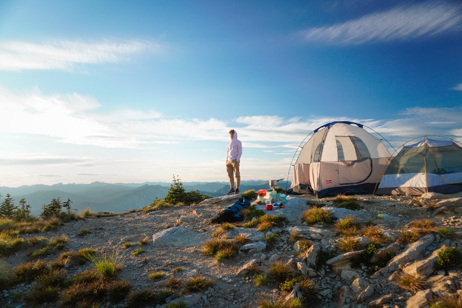A man is enjoying camping on the top of a mountain