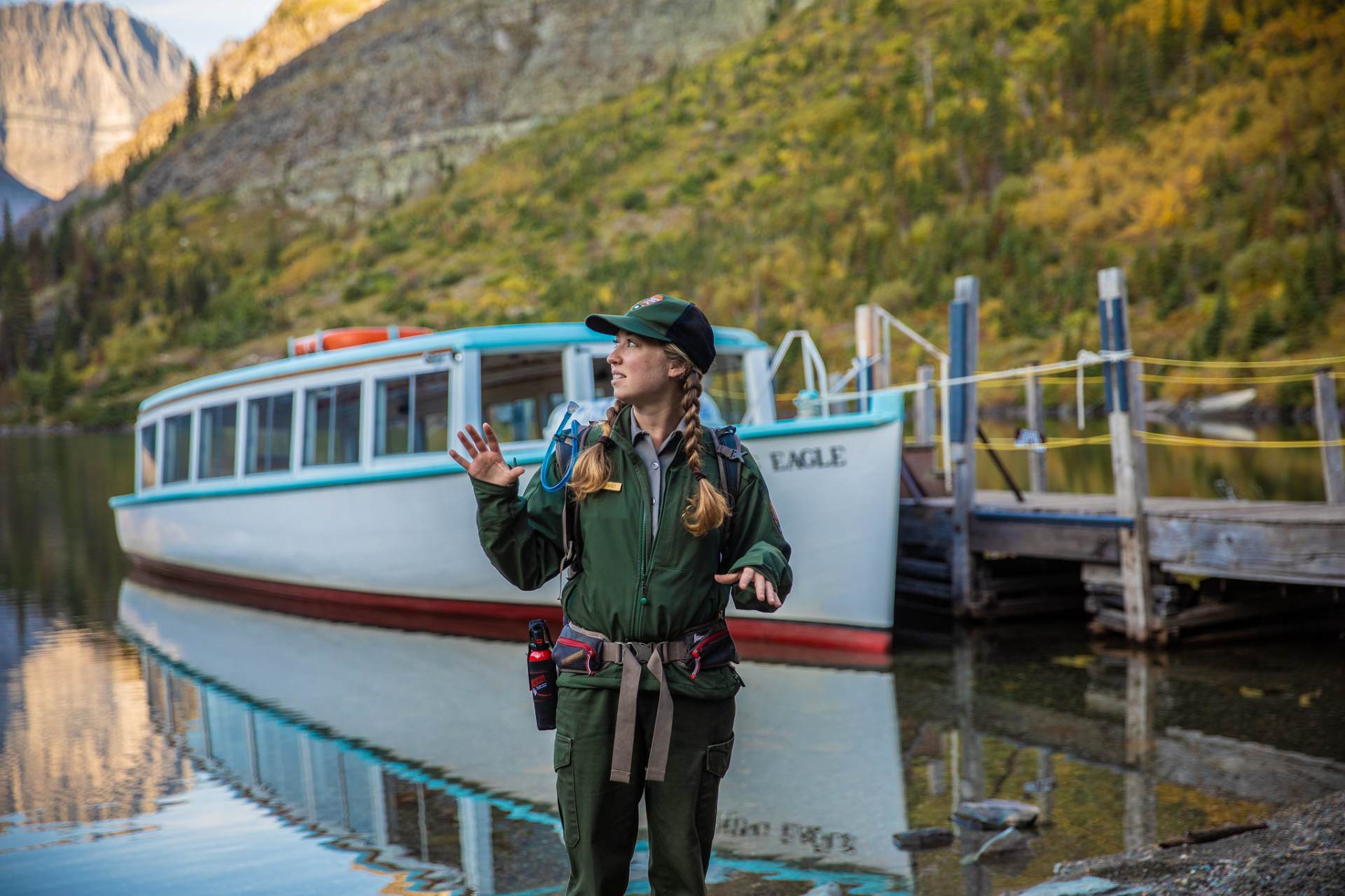 A National Park Ranger stands in front of a historic tour boat