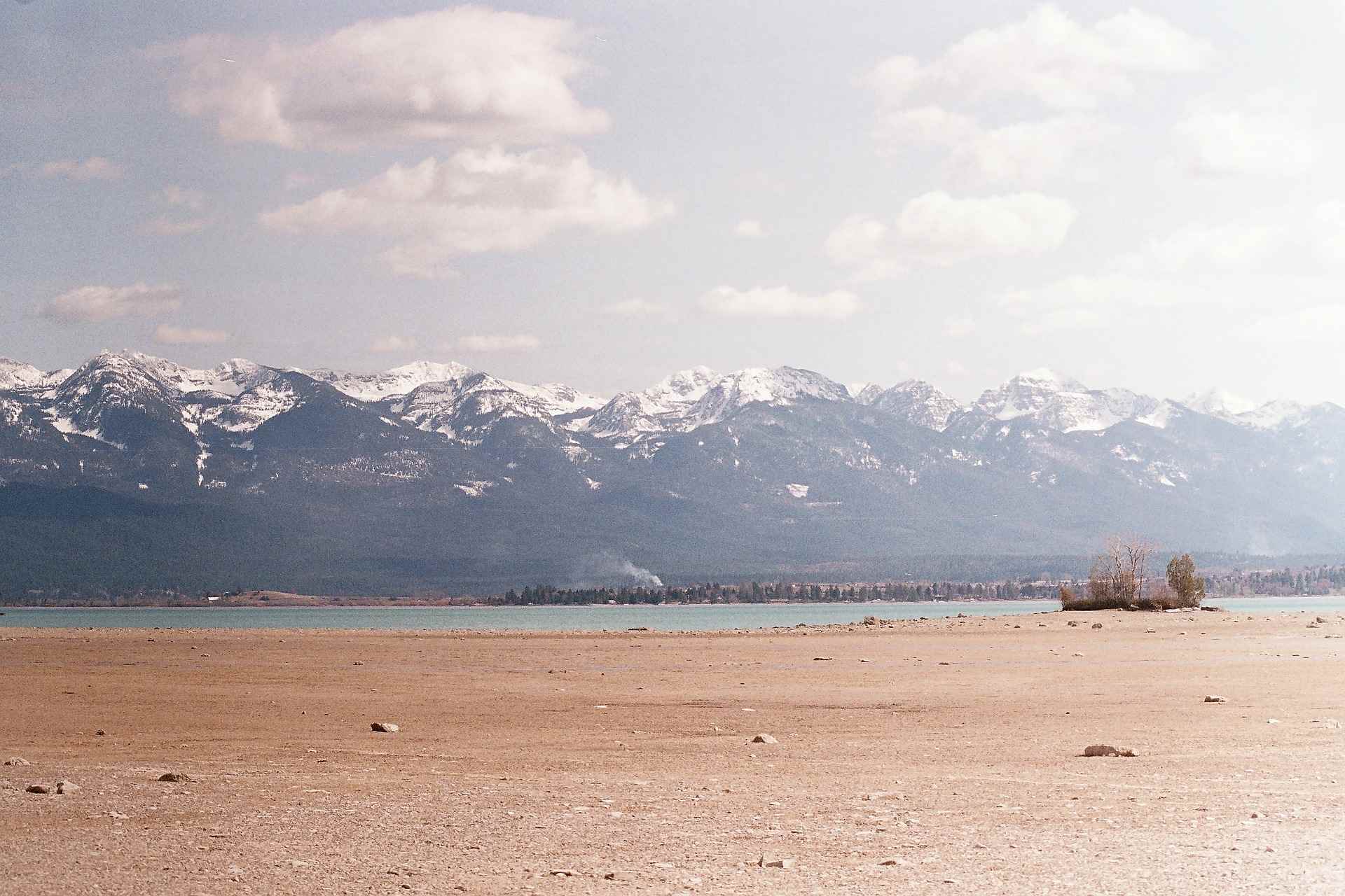 Flathead Lake beach and Mission Mountains on a cloudy day