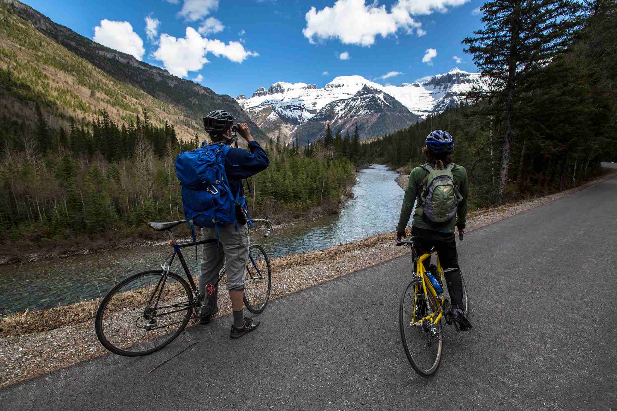 two bikers in Glacier Park looking at mountains