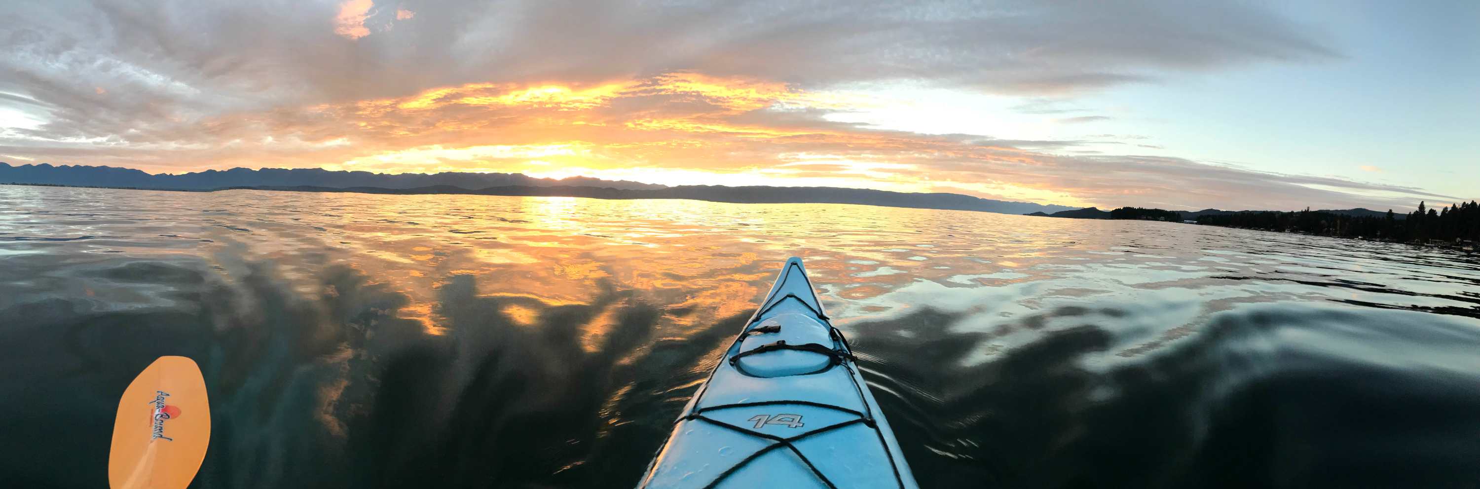 kayak on Flathead Lake with sunrise in background