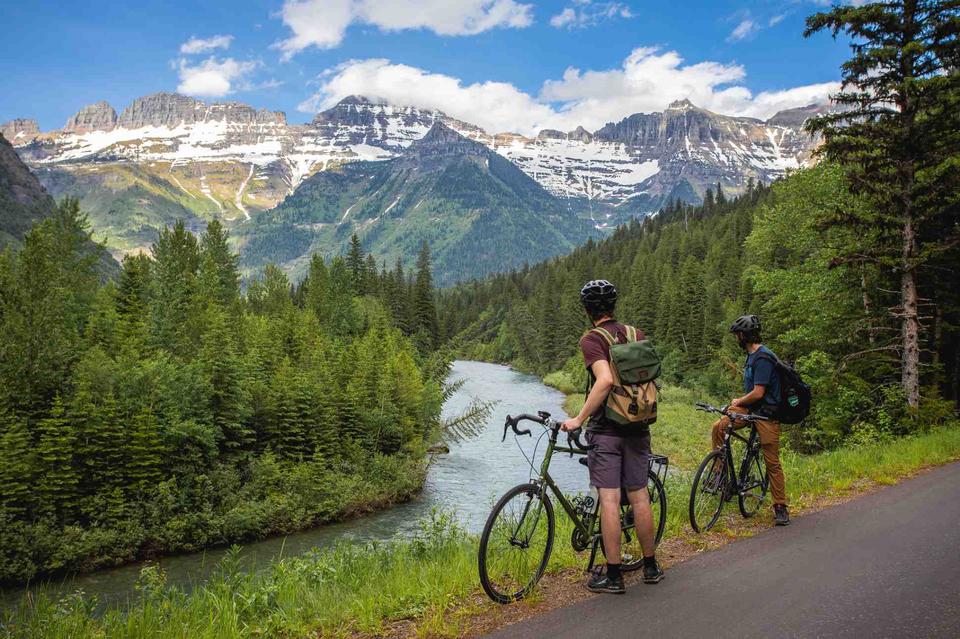 two bicyclists view a river along going_to_the_sun road in Glacier Park