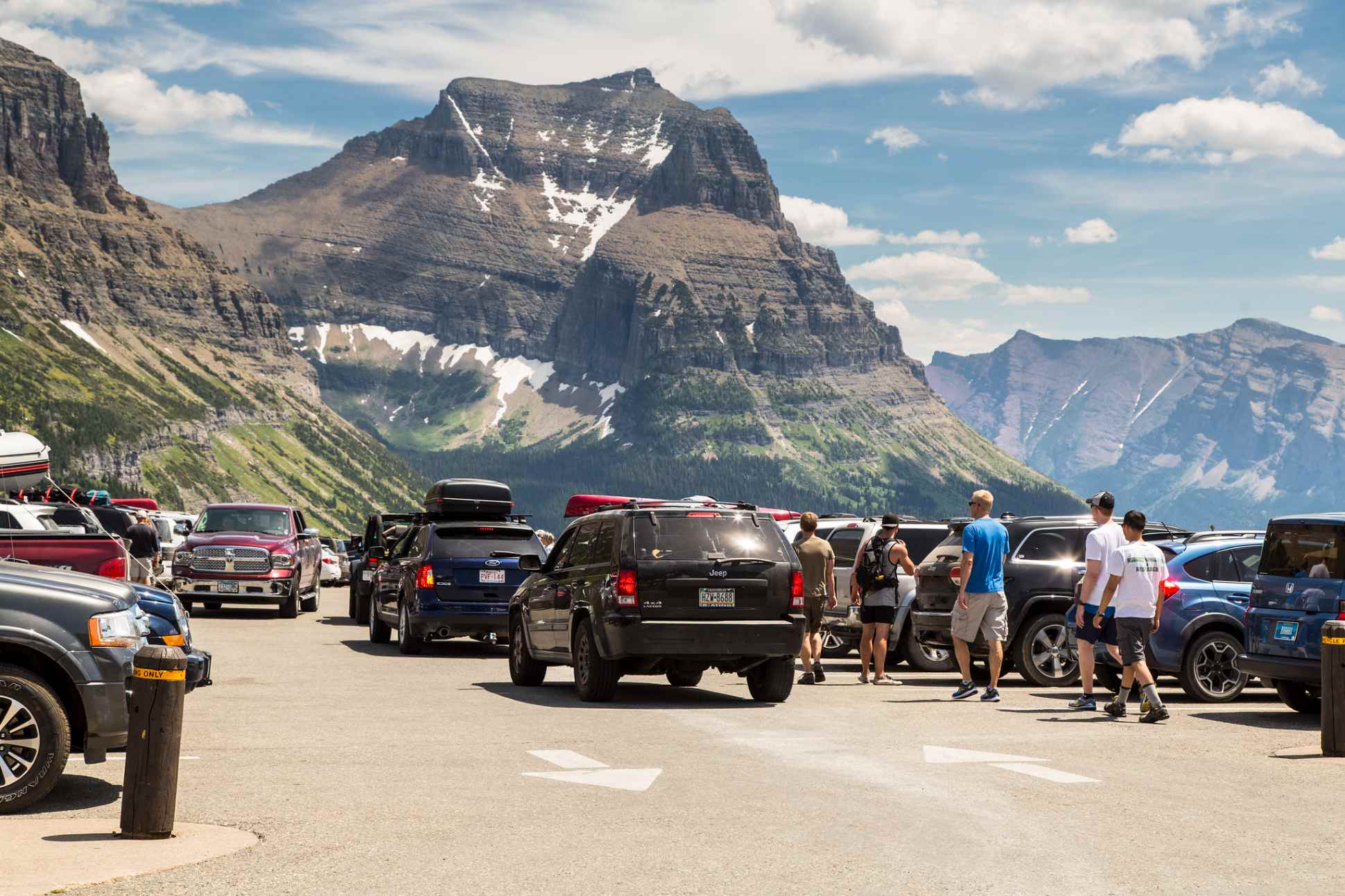 visitors and cars in Logan Pass parking lot