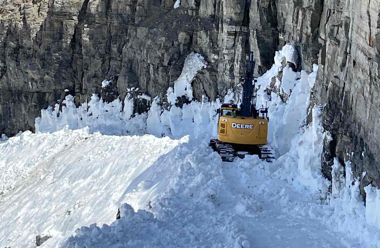 excavator on a snowy road in Glacier Park