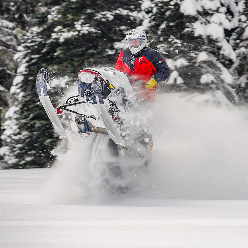An experienced snowmobiler riding through powder